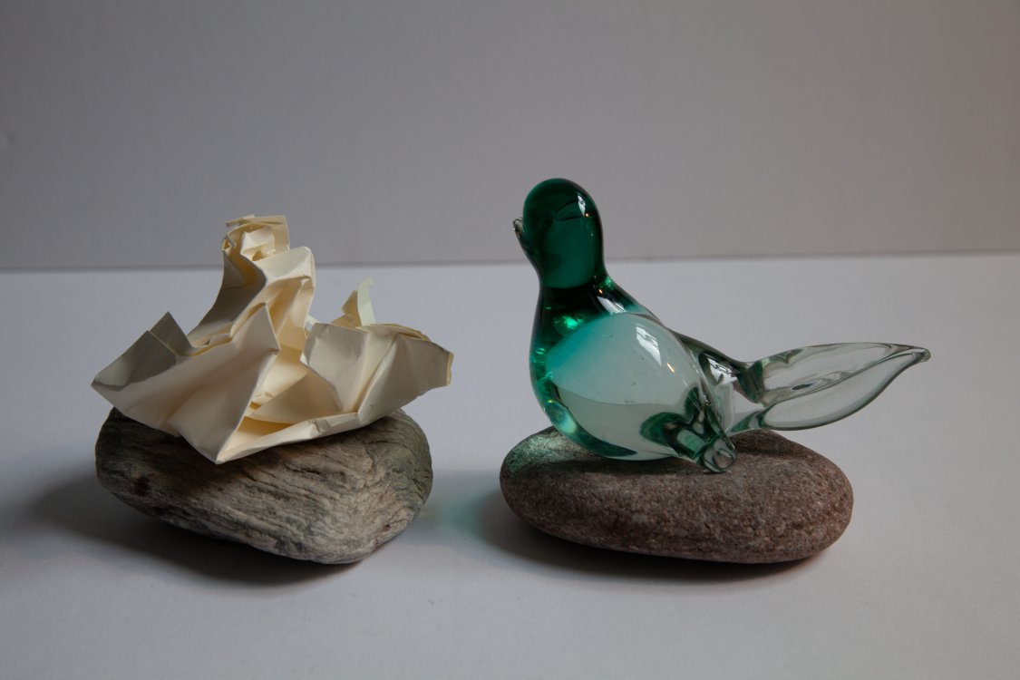 glass bird, rocks and paper